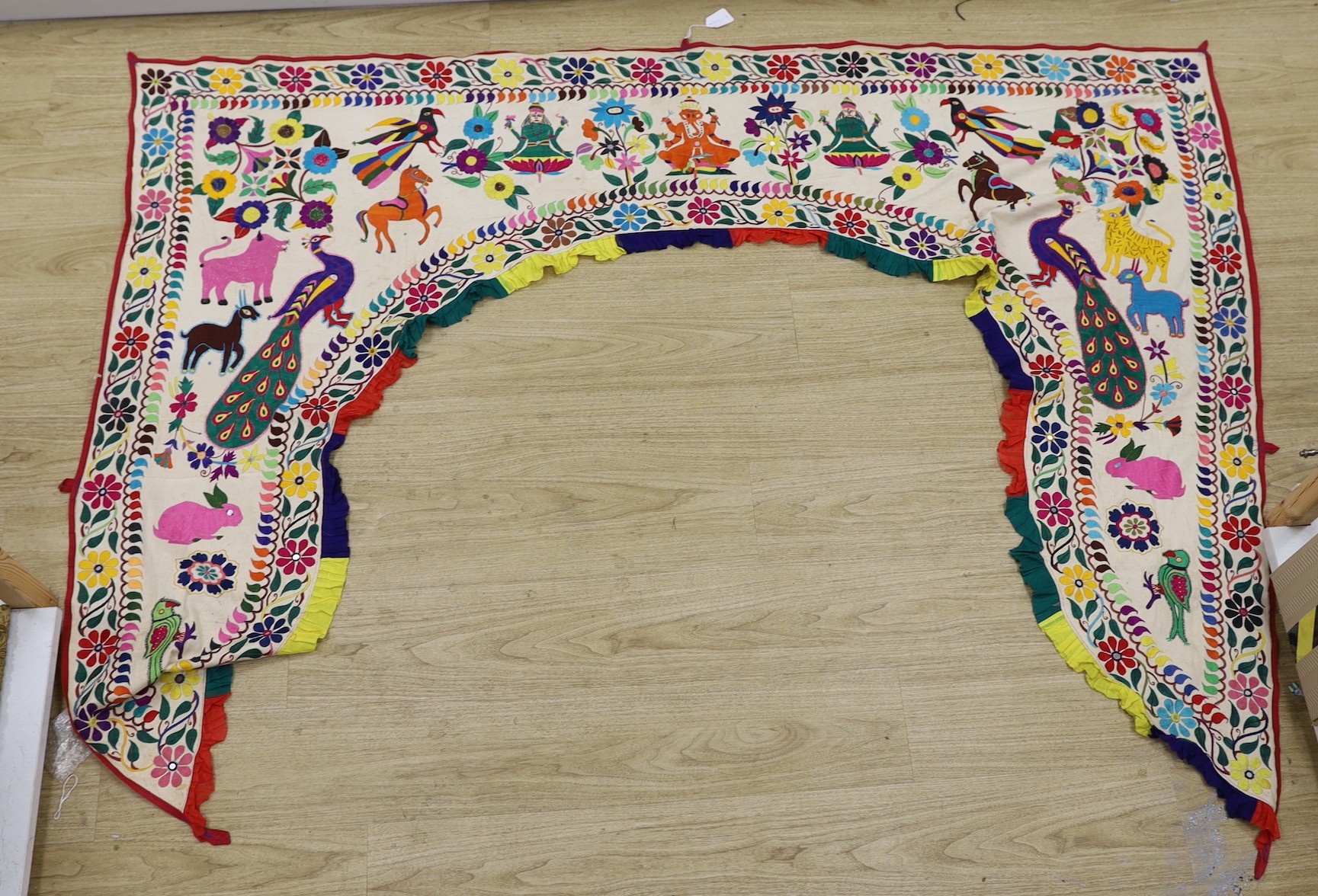 An Indian embroidered arched door panel, 84cms wide x 152 high